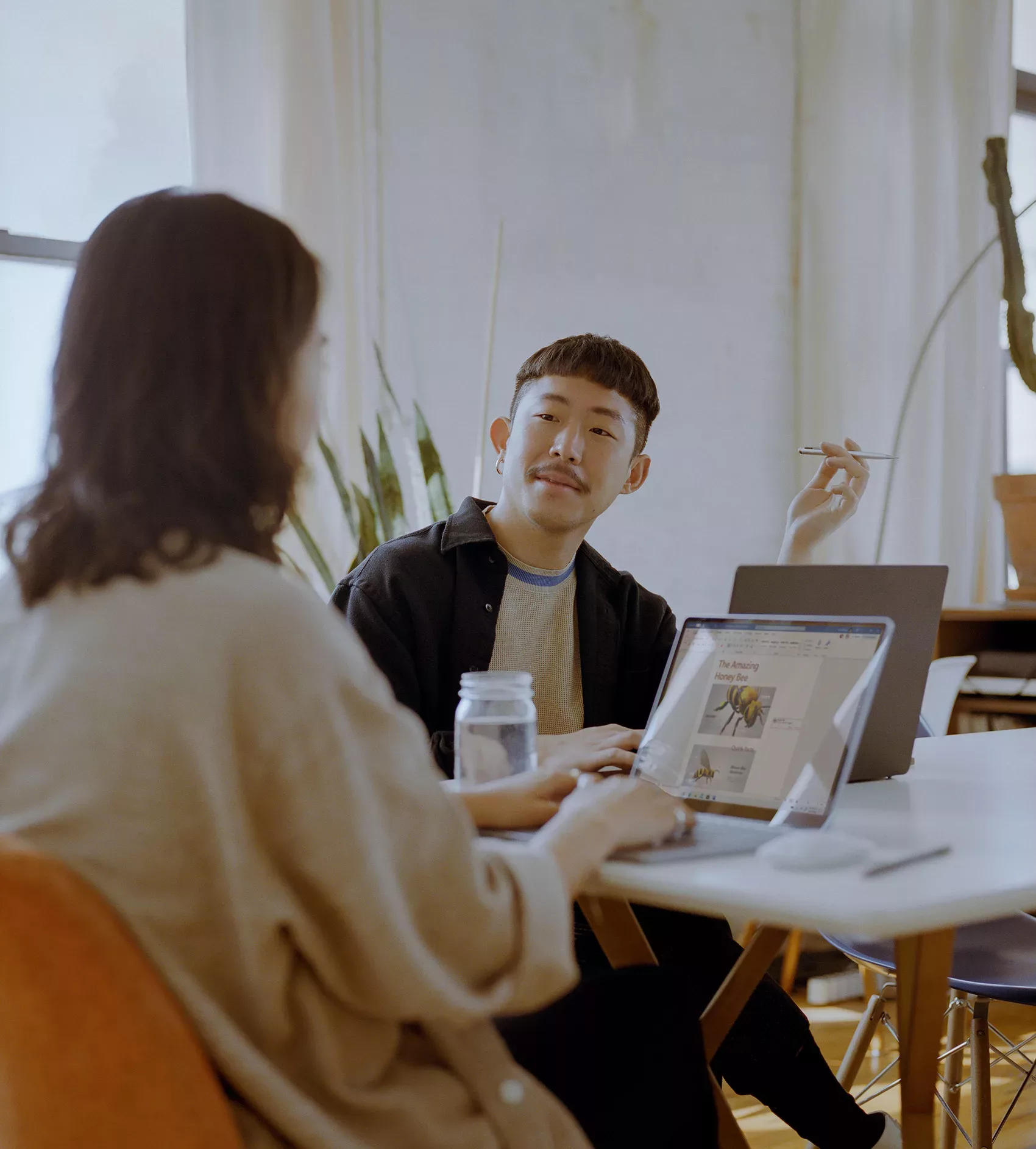 Un homme et une femme assis sur un bureau collaborent